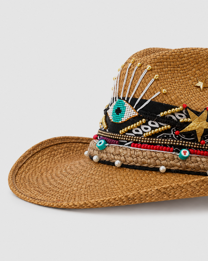 Boho Panama straw hat with pearl accents, woven details and handcrafted Colombian evil eye design photographed on white background