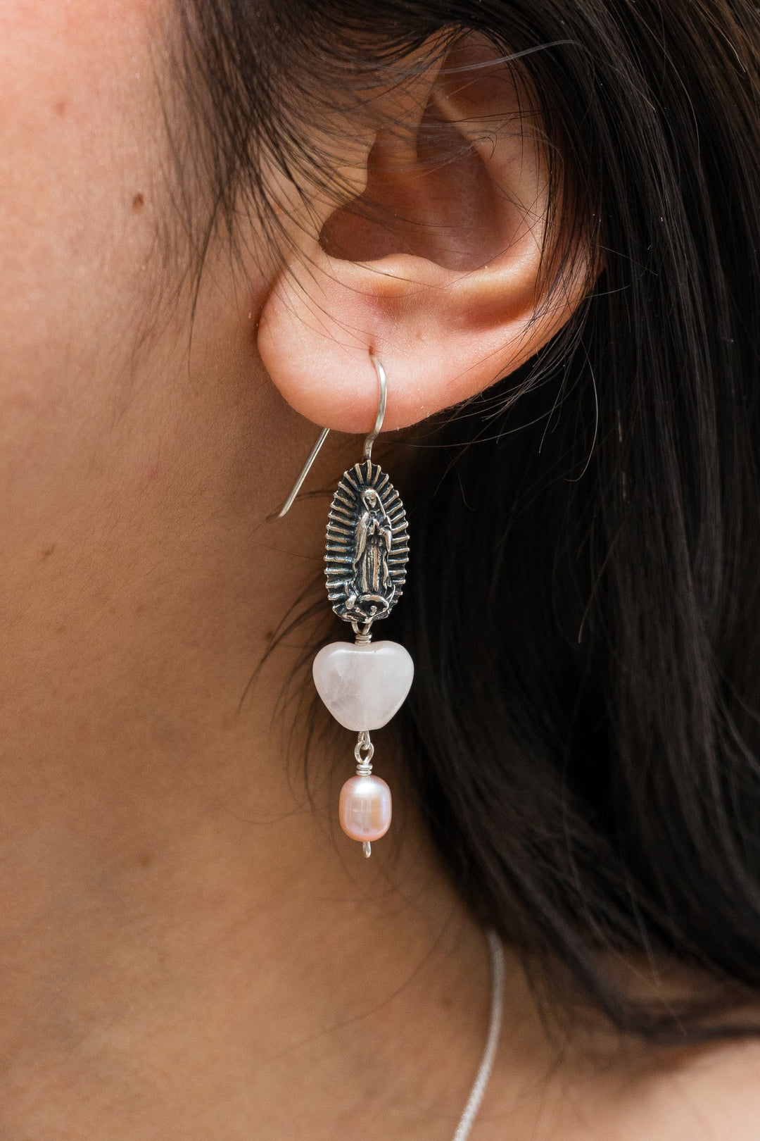 Woman wearing Mexican Virgen de Guadalupe silver earrings by Bootsologie