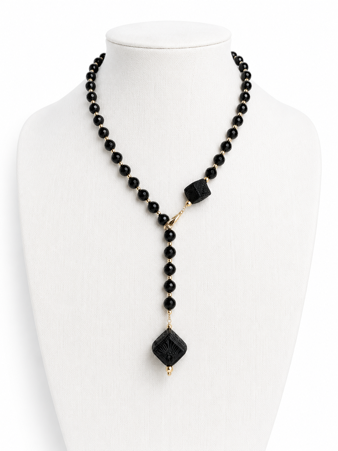 Authentic Barro Negro black clay necklace photographed on white background featuring handmade Mexican ceramic cube pendants, black faceted beads, and elegant gold accents by Bootsologie.