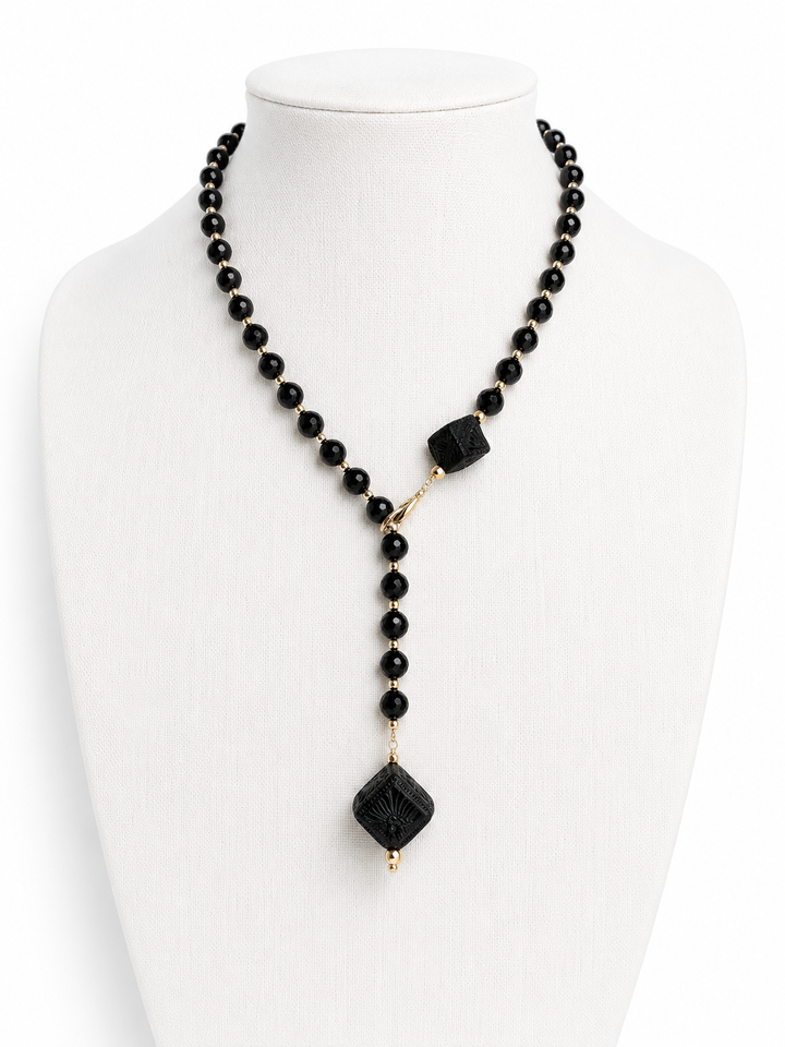 Authentic Barro Negro black clay necklace photographed on white background featuring handmade Mexican ceramic cube pendants, black faceted beads, and elegant gold accents by Bootsologie.