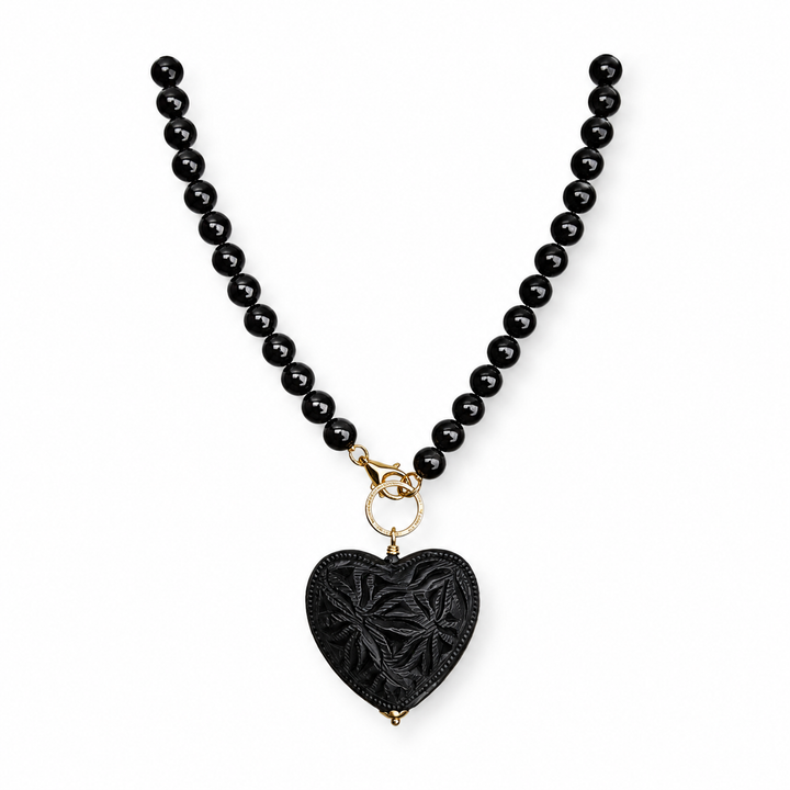 Genuine Oaxacan black clay necklace on white background with hand carved Barro Negro heart pendant, artisan Mexican statement jewelry by Bootsologie.