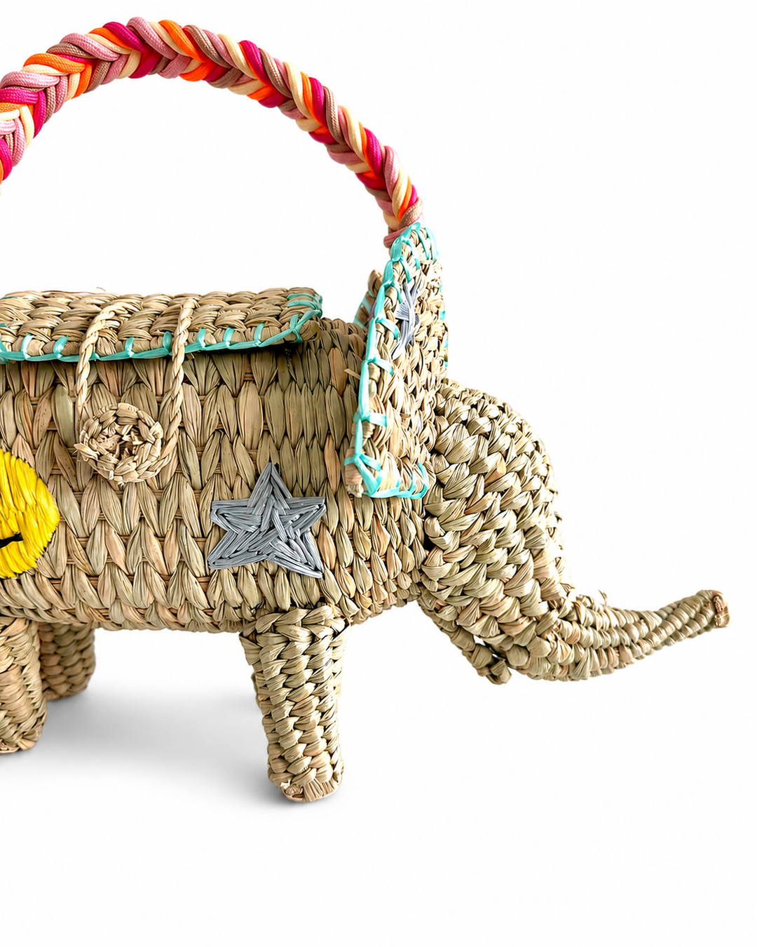 Close-up of embroidered rainbow detail and turquoise stitched ear on artisan elephant straw handbag.