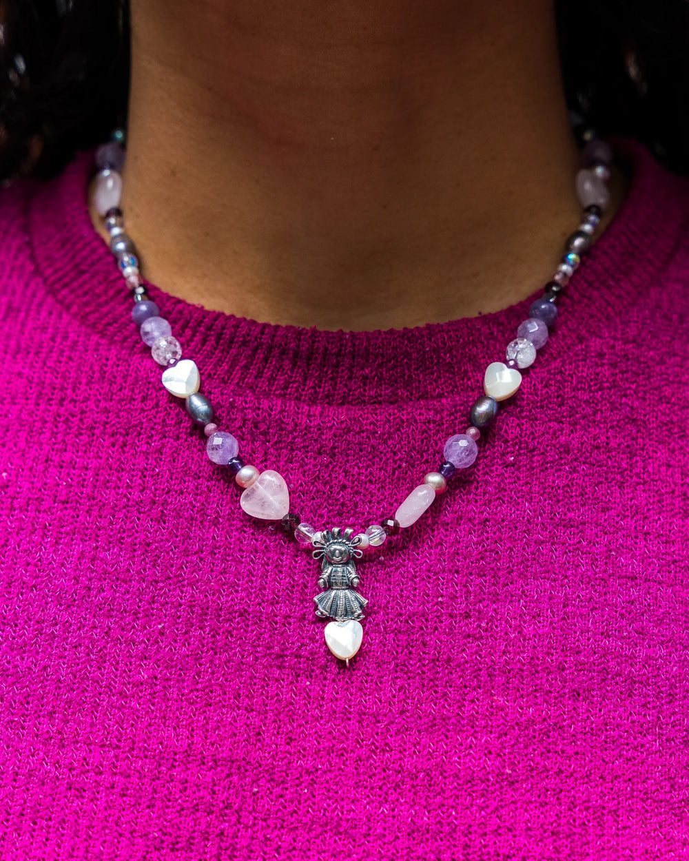 Woman wearing handmade Mexican doll gemstone necklace with purple natural stones and Muñeca Mexicana charm