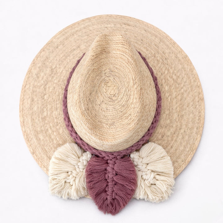 Handmade Colombian straw hat with rose and ivory macramé tassel band on white background