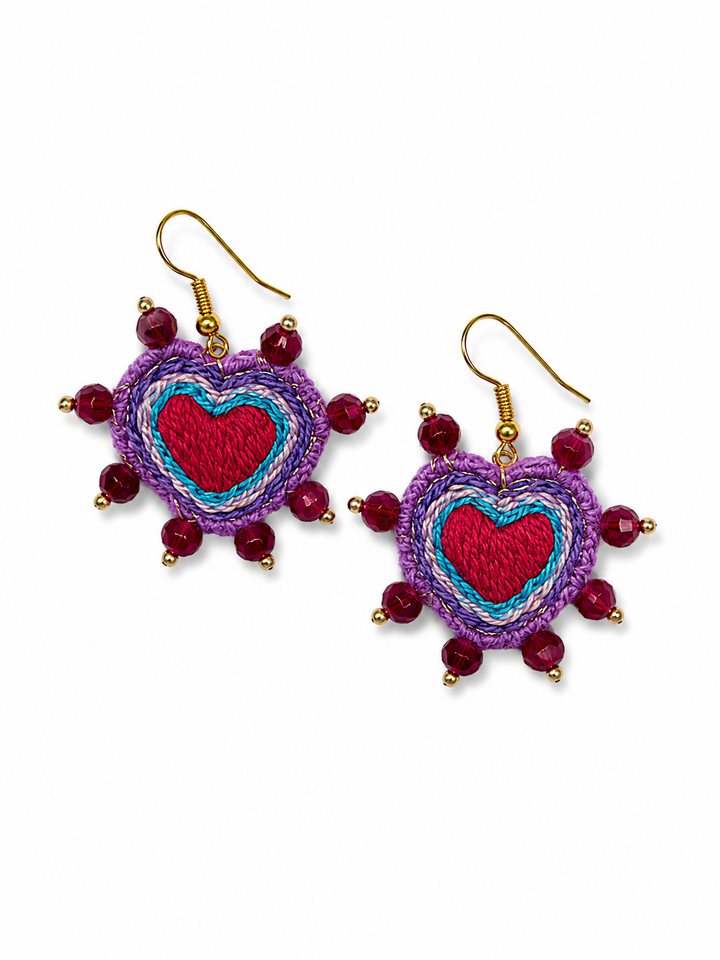 Purple embroidered heart earrings with crystal bead details and gold hooks on white background