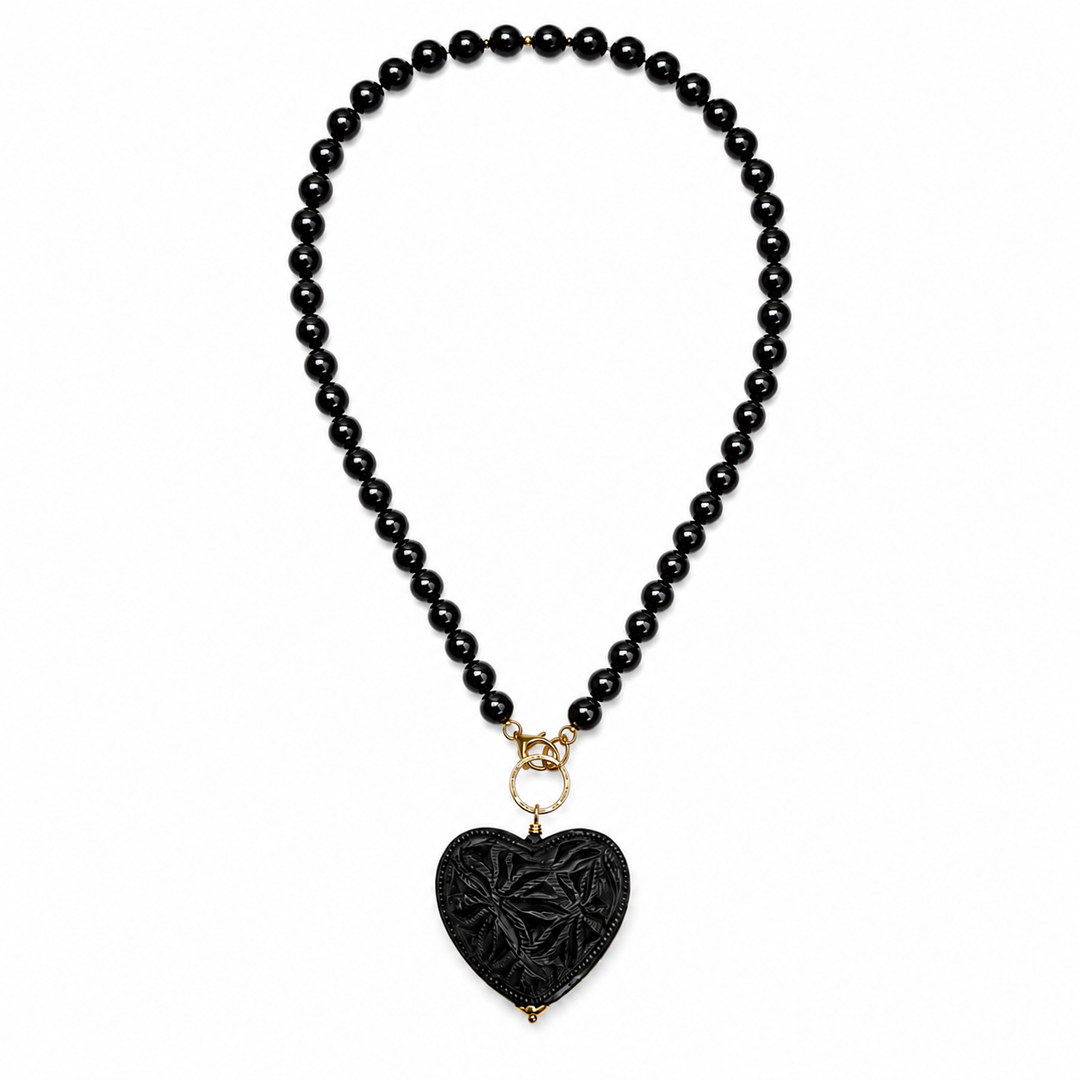 Artisan Barro Negro necklace with carved black heart pendant styled on white background, handmade Mexican jewelry by Bootsologie with elegant boho statement design.