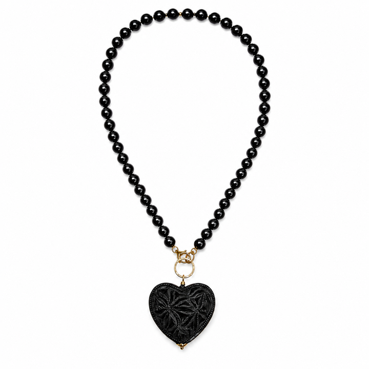 Artisan Barro Negro necklace with carved black heart pendant styled on white background, handmade Mexican jewelry by Bootsologie with elegant boho statement design.