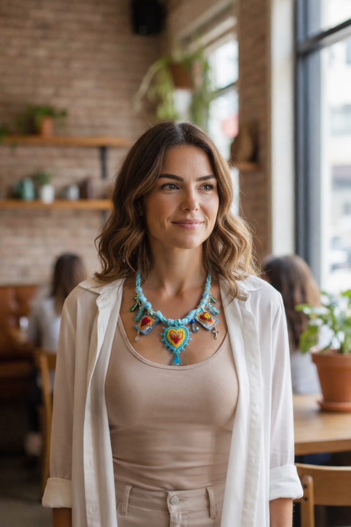 Model wearing Mexican embroidered heart necklace, artisan statement jewelry by Bootsologie