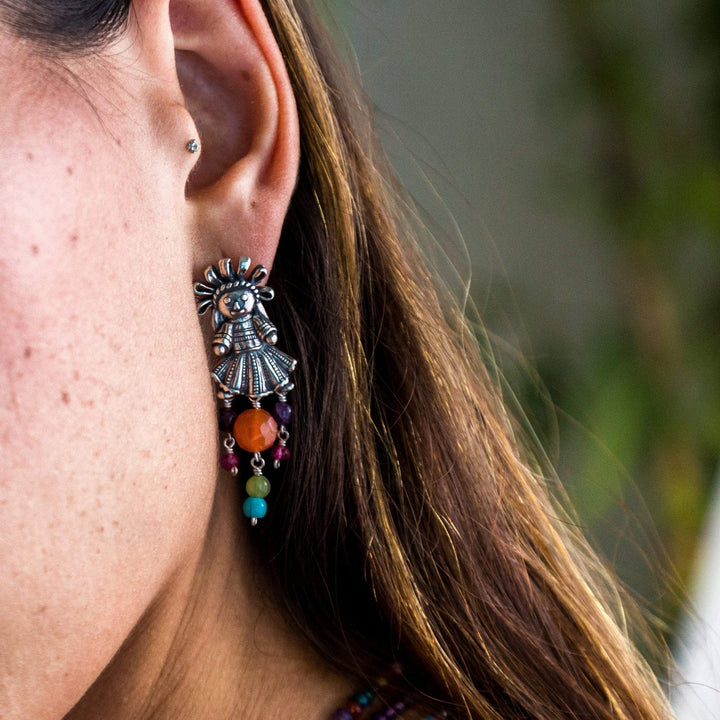 Woman wearing handmade Muñeca Mexicana sterling silver earrings