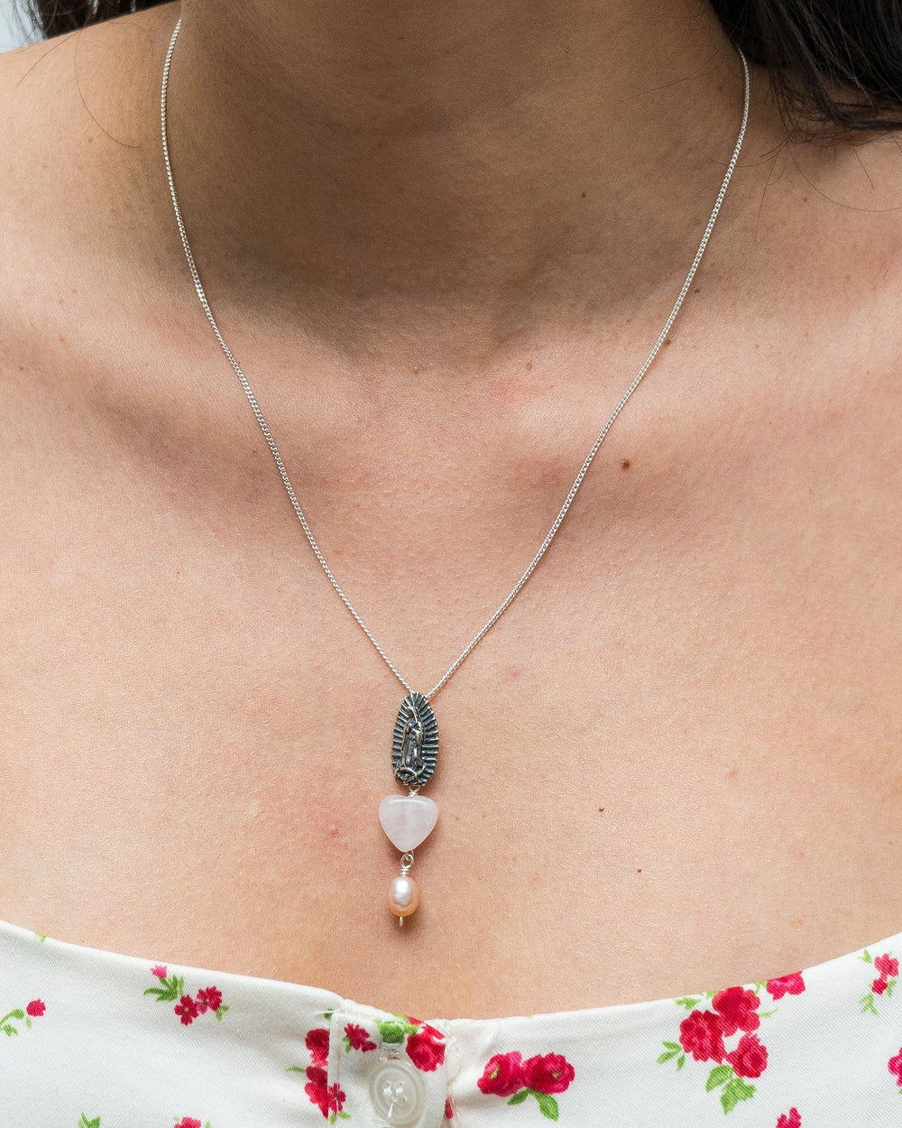 Close-up of Virgen de Guadalupe silver pendant with colorful quartz and rose tourmaline details