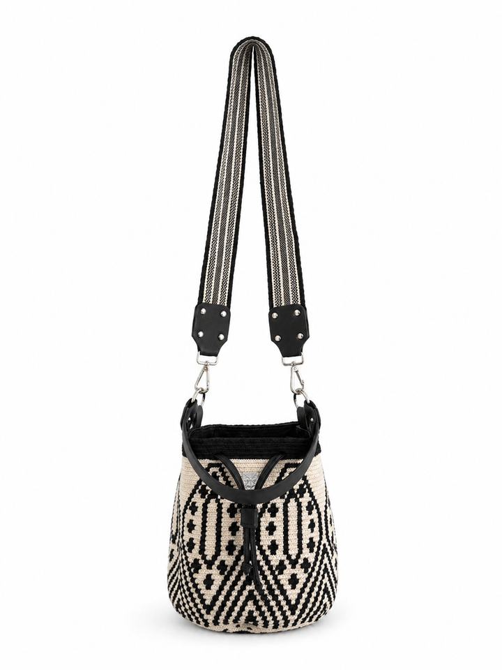     Black and cream woven bucket bag with geometric pattern and wide striped strap on white background Bootsologie