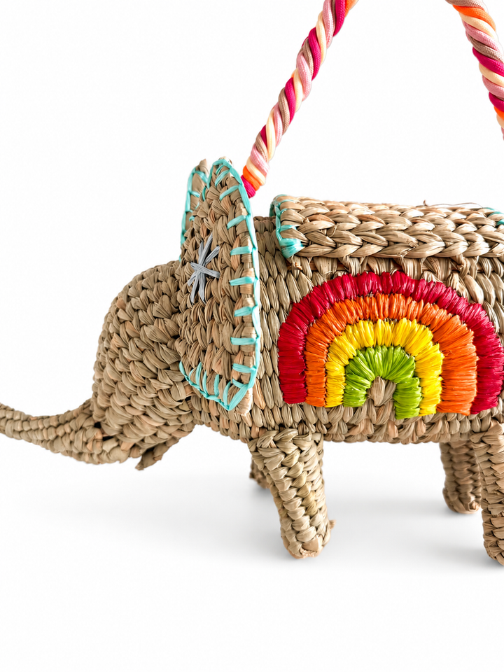 Side view of one of a kind elephant shaped straw purse with rainbow embroidery and artisan stitched details.