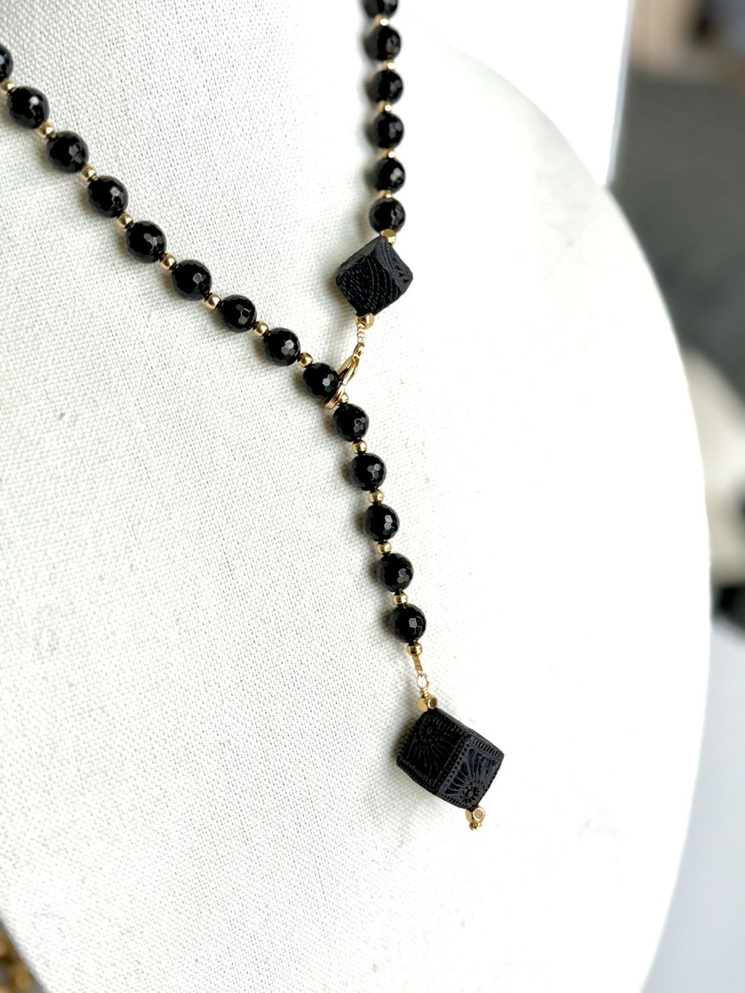 Artisan black clay Oaxaca necklace on pure white background, modern boho Mexican jewelry handcrafted with genuine Barro Negro ceramic details and black beaded chain by Bootsologie.