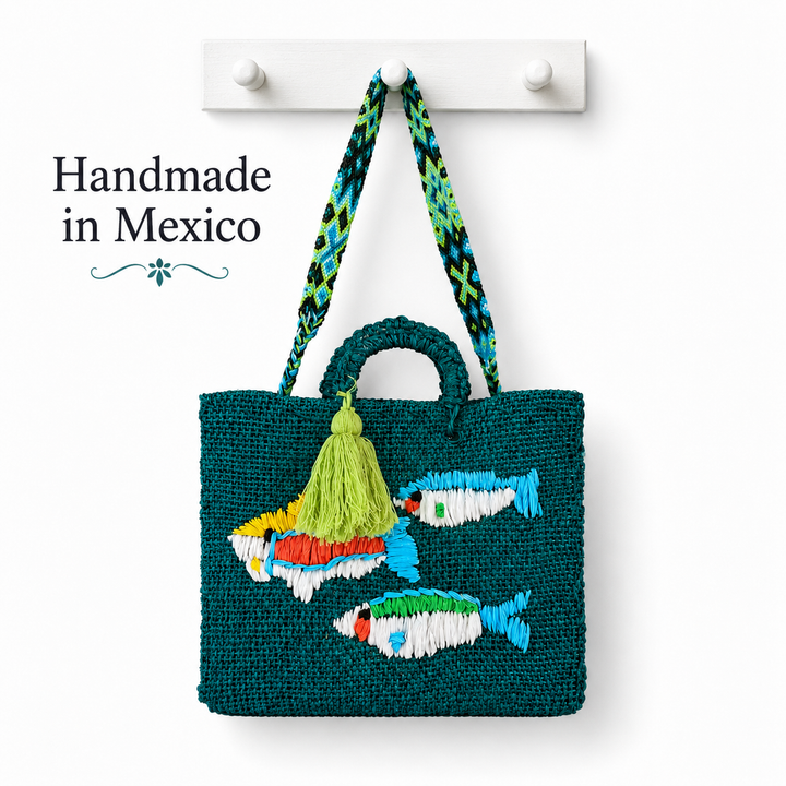 Handmade Mexican fish tote bag in teal woven ixtle fiber with colorful embroidered fish and artisan tassel on white background