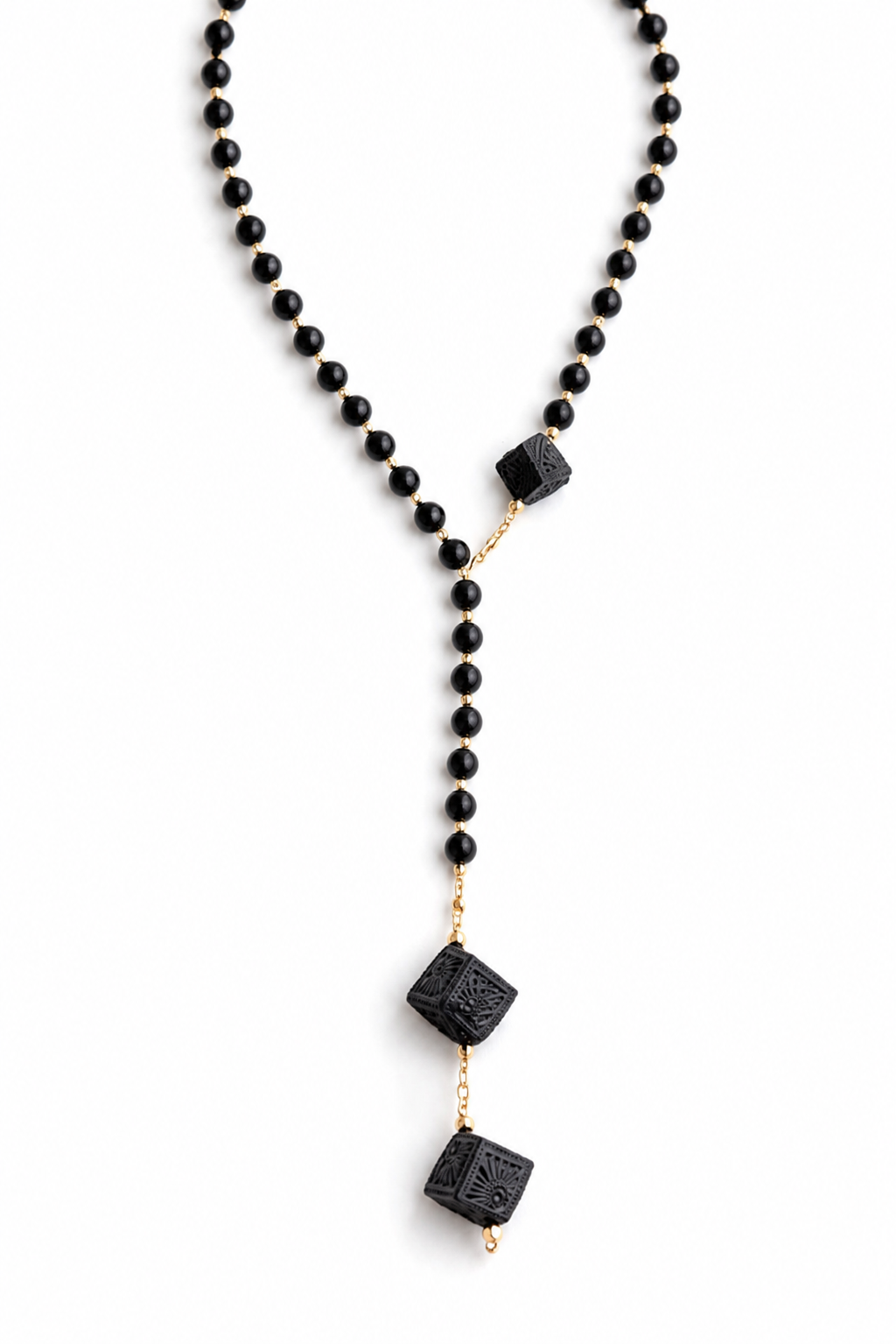 Handmade black clay Barro Negro necklace displayed on a clean white background, artisan Mexican statement jewelry by Bootsologie with faceted black beads and carved Oaxaca clay pendant.