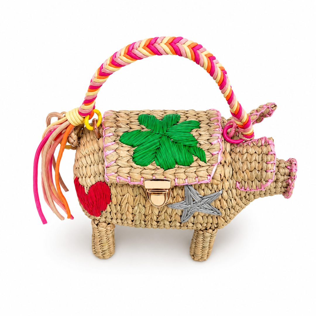     Close-up of hand embroidered pig straw bag with colorful stitched accents, gold-tone clasp, and textured woven surface.