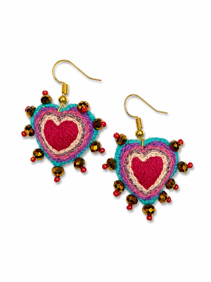 Hand embroidered Sacred Heart earrings with turquoise trim and colorful bead accents on white background