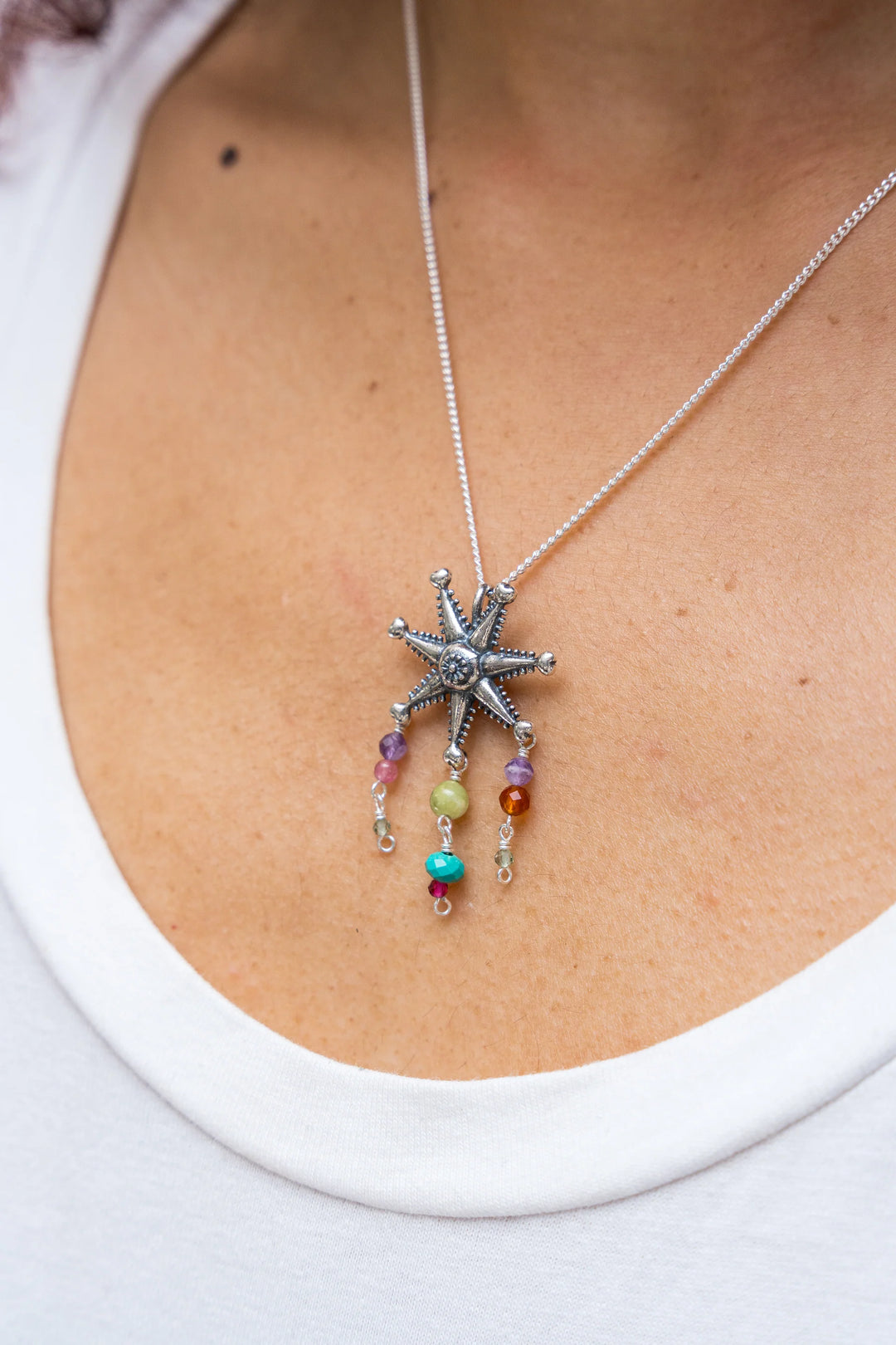 Woman wearing Mexican silver piñata gemstone necklace with colorful stone accents
