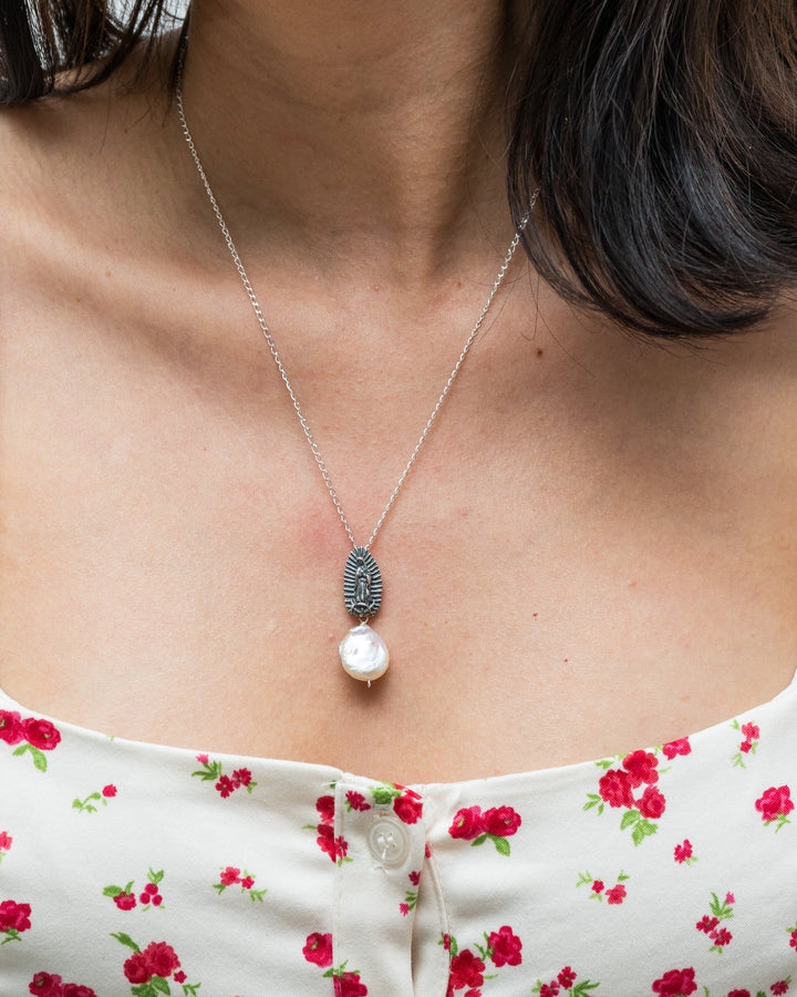 Close-up of Virgen de Guadalupe silver pendant with pearl drop accent