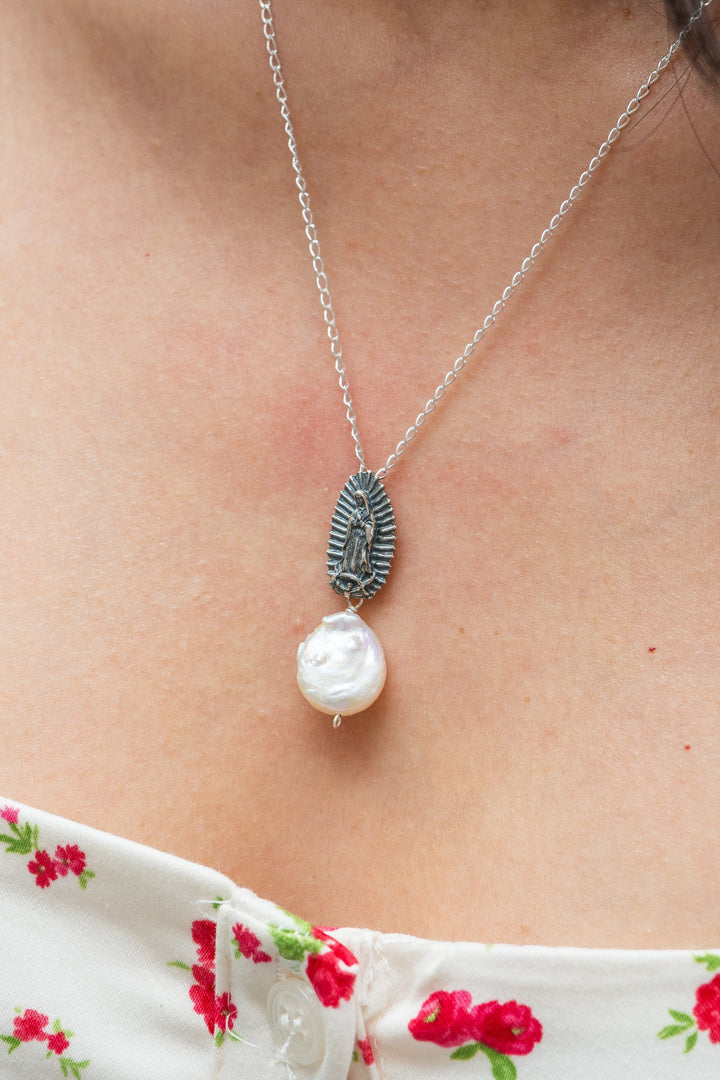 Close-up of Virgen de Guadalupe silver pendant with pearl drop accent