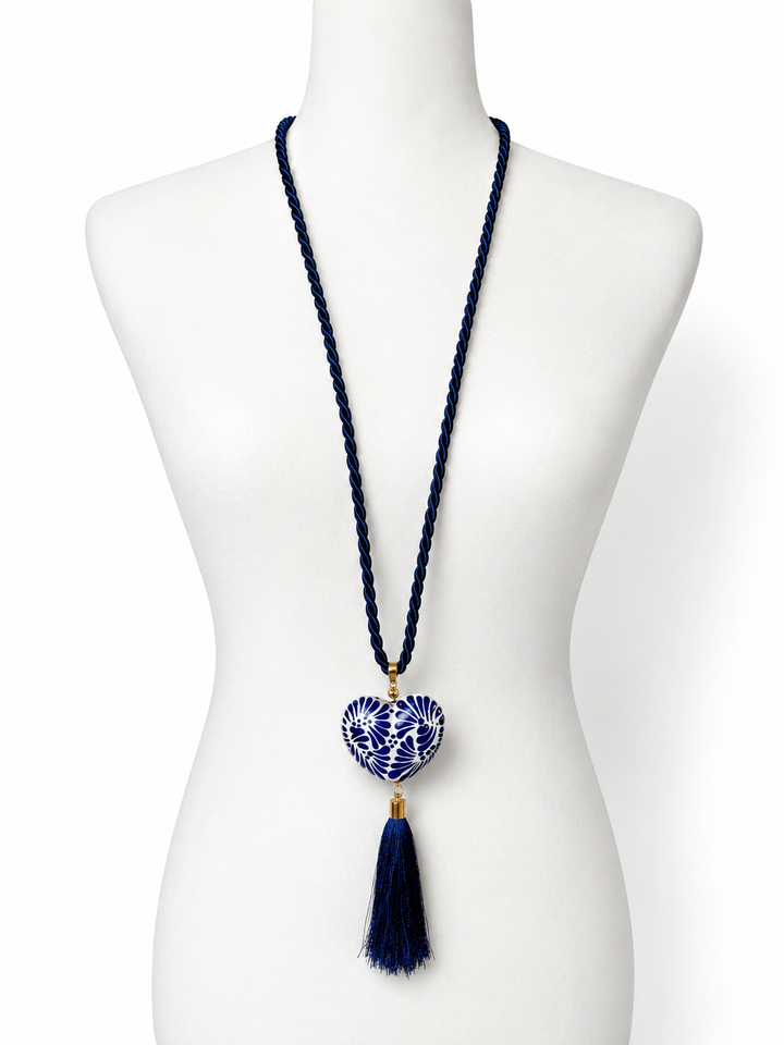 Blue and white Talavera ceramic heart pendant necklace with long navy tassel on white background