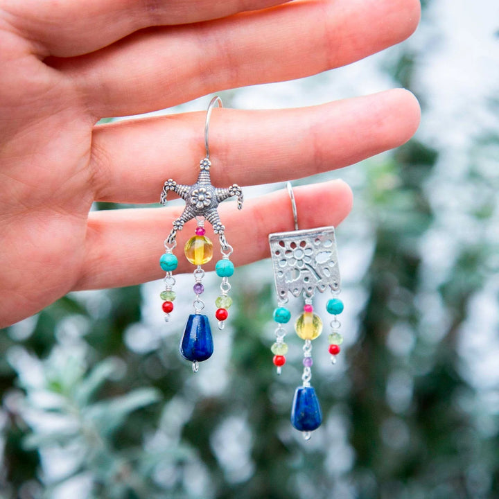  Close-up of papel picado motif silver earrings featuring deep blue lapis lazuli gemstones