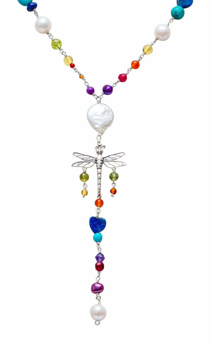 Close-up of silver dragonfly pendant with colorful natural gemstones and pearl accents