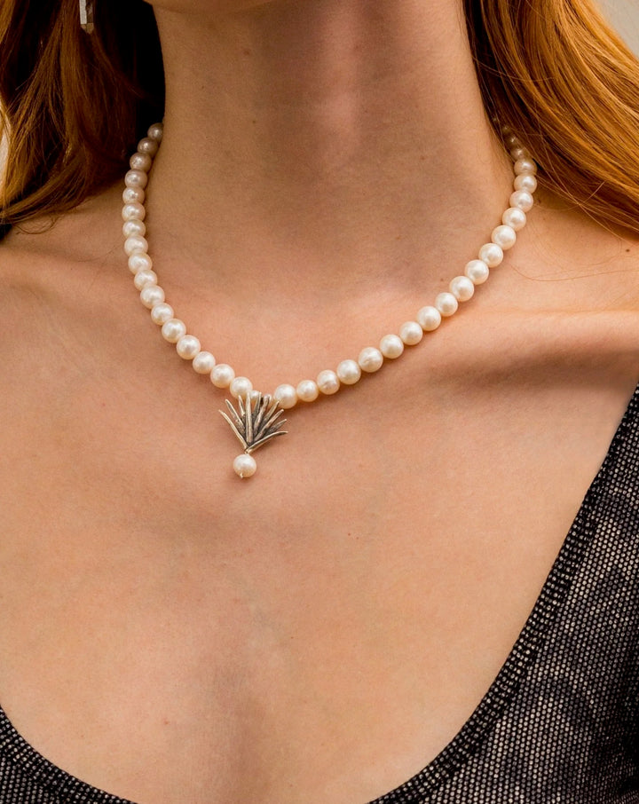 Close-up of pearl agave necklace with silver pendant and pearl drop detail