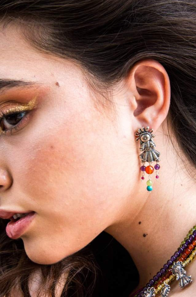 Woman wearing handmade Muñeca Mexicana sterling silver earrings
