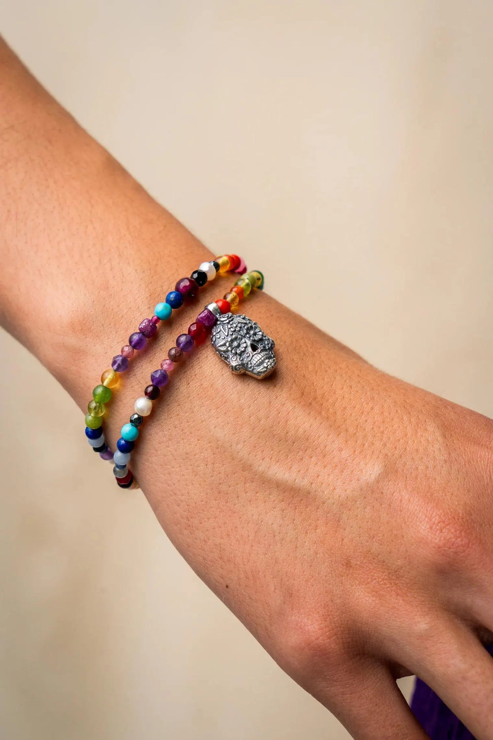 Close-up of Catrina Calaca charm bracelet with colorful natural gemstones and silver detail