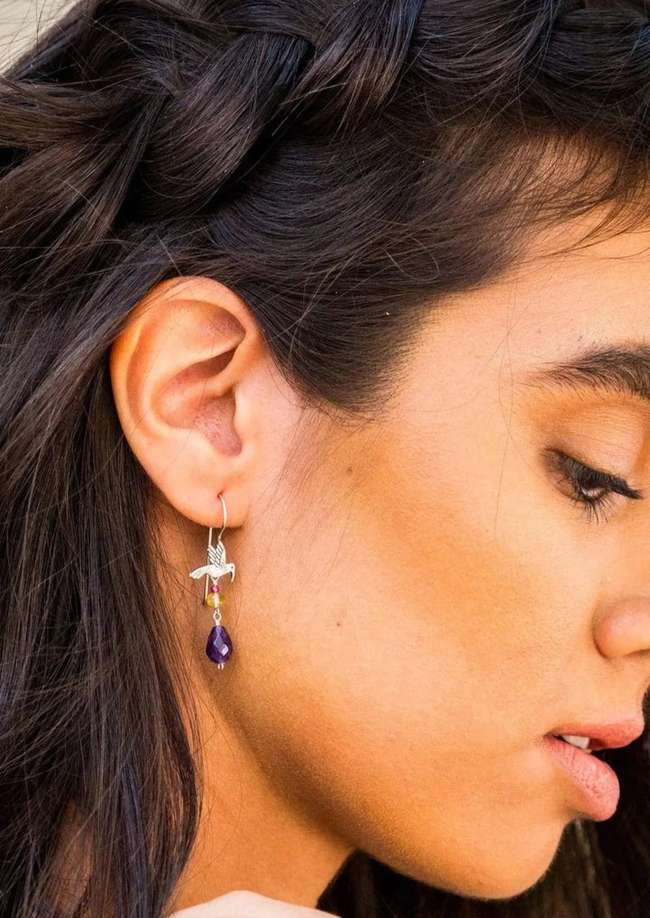 Woman wearing handmade Mexican hummingbird silver earrings by Bootsologie