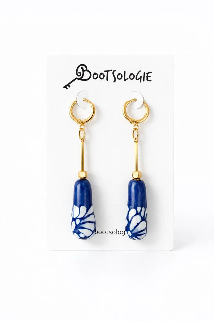 Mexican Talavera ceramic drop earrings with blue and white hand-painted charms and gold plated brass hoops on Bootsologie card