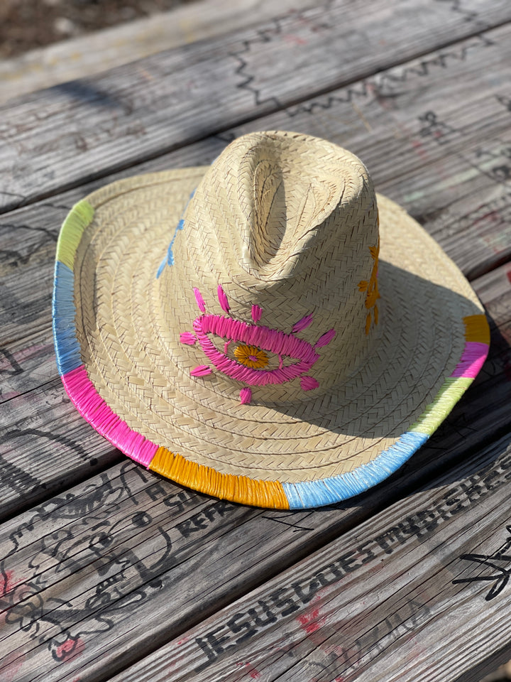 Women’s embroidered straw sun hat styled for beach, resort, and sunny summer outfits