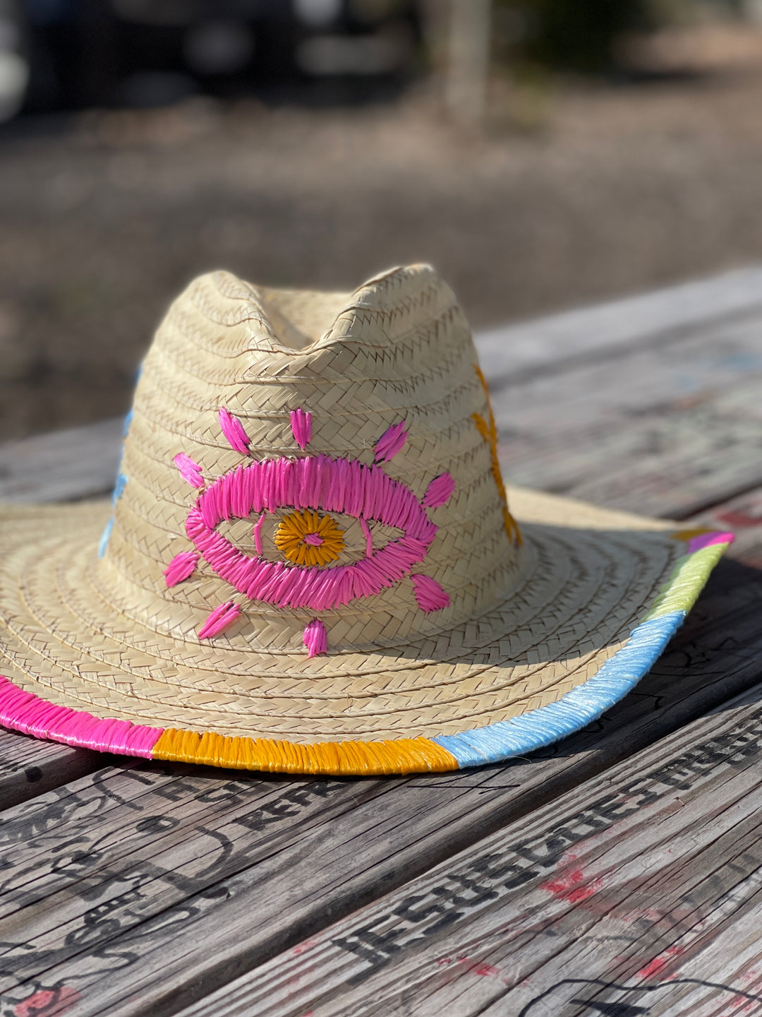 Hand embroidered straw sun hat styled with summer accessories for a boho vacation look