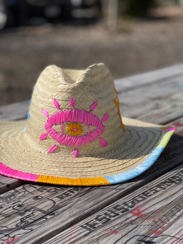 Hand embroidered straw sun hat styled with summer accessories for a boho vacation look